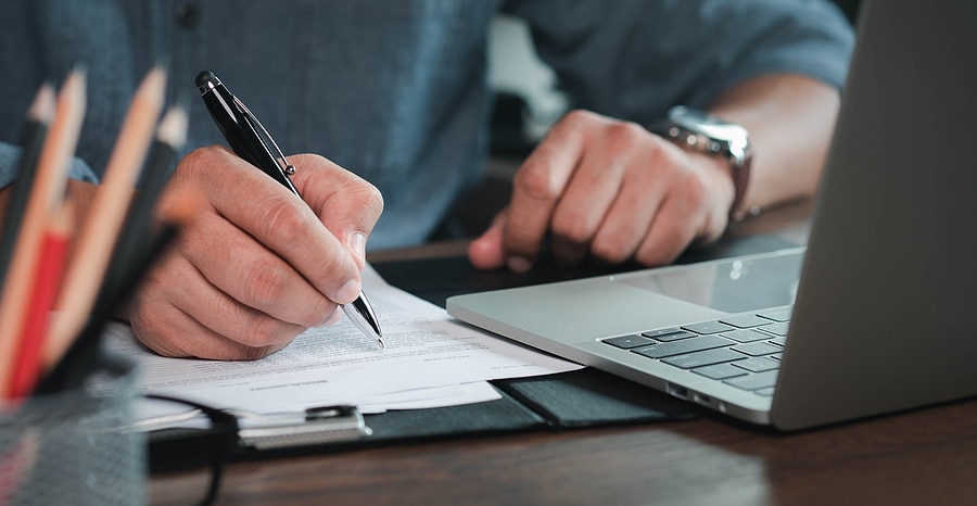 Close-up Of Man Using Writing Notebook Paper